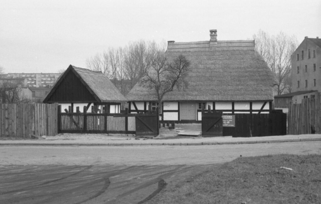 Podwórze gospodarcze od strony bramy wjazdowej - budynek mieszkalny i gospodarczy. Na pierwszym planie ulica, a w tle fragmenty budynku muzeum (kliknięcie spowoduje powiększenie zdjęcia)