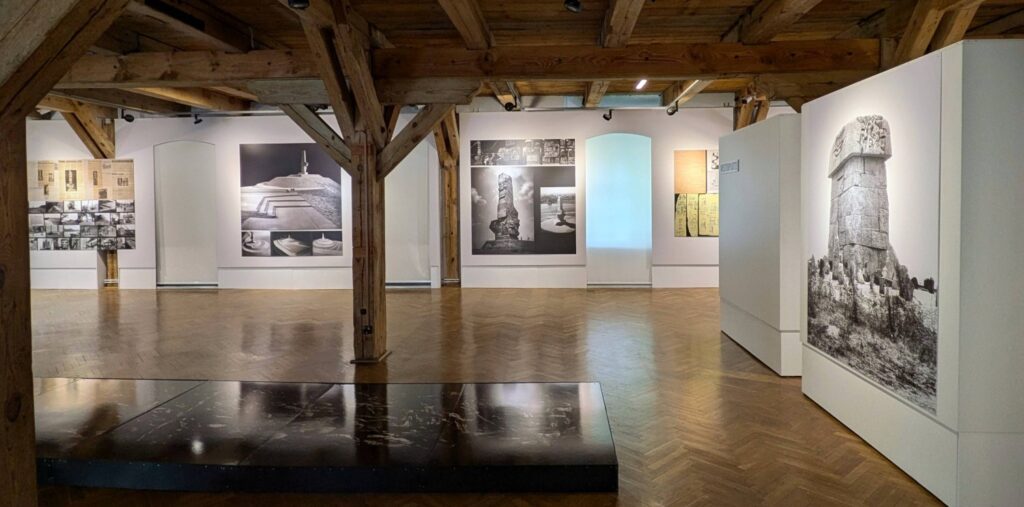 Sala wystawowa. Na ścianach wiszą plansze z fotografiami prezentującymi pomniki (kliknięcie spowoduje powiększenie zdjęcia).